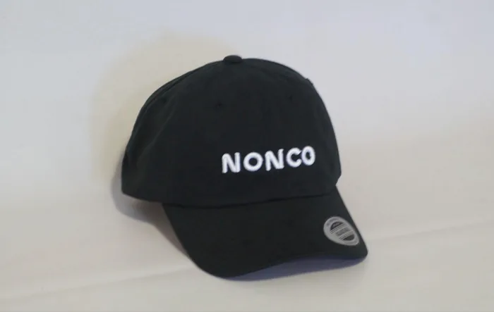 Gorra negra con nombre de empresa bordado en hilo blanco