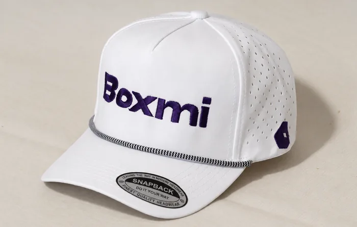 Gorra blanca con cordón al frente y logotipo bordado en azul marino